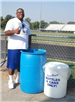 Coach Parker poses with recycling bins to support the Recycling at Port Allen High School program