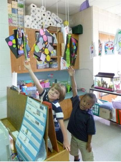Two children pose with their artwork
